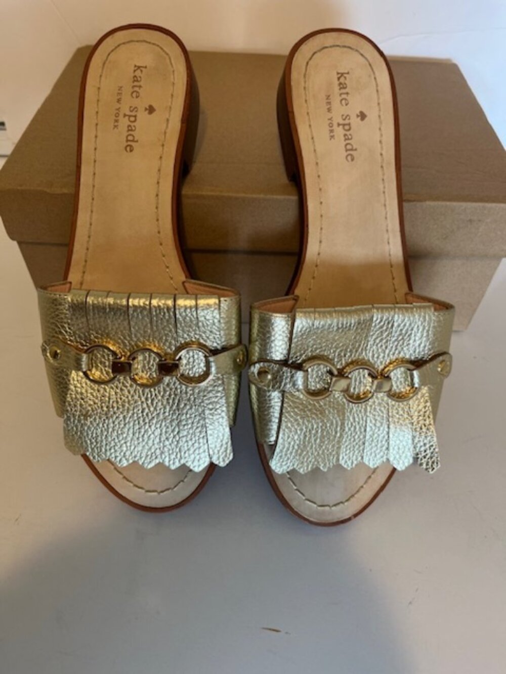 Kate Spade New York gold slide sandal.